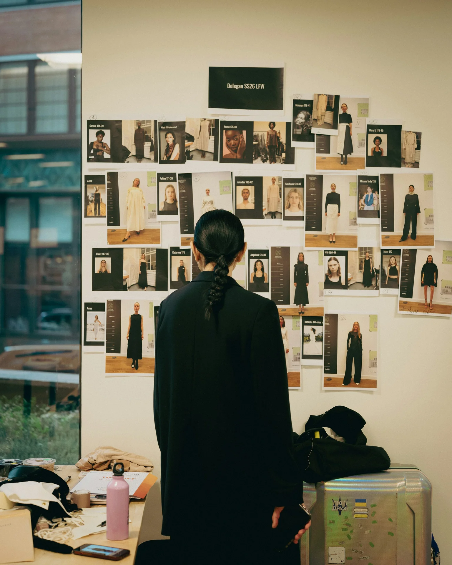Designer reviewing a fashion mood board covered in casting and look images