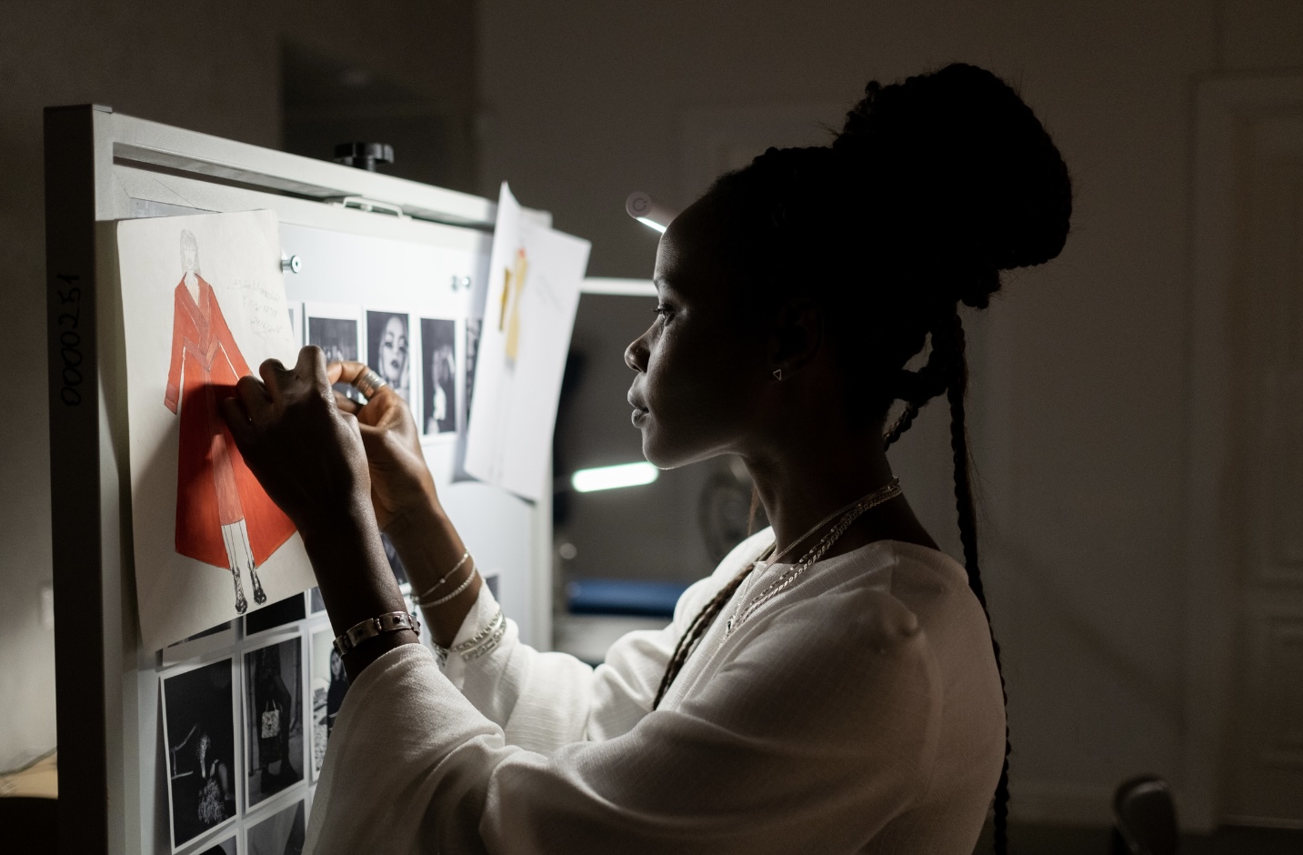 Fashion founder reviewing strategy notes and references on a studio whiteboard